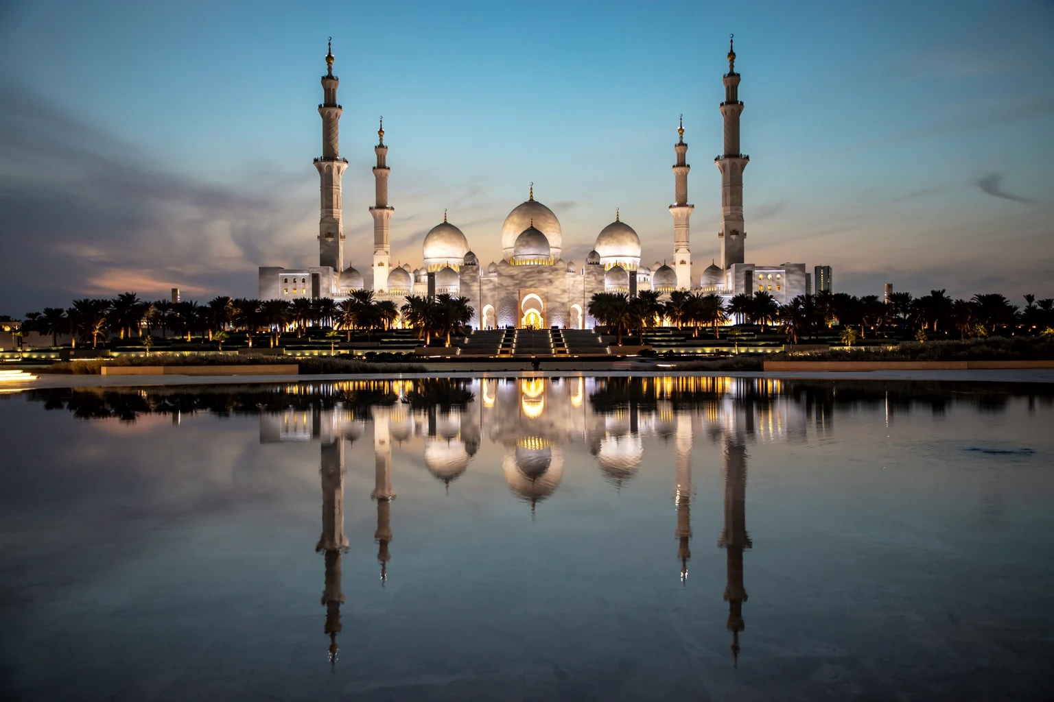The Sheikh Zayed Grand Mosque at dusk reflected in the pools