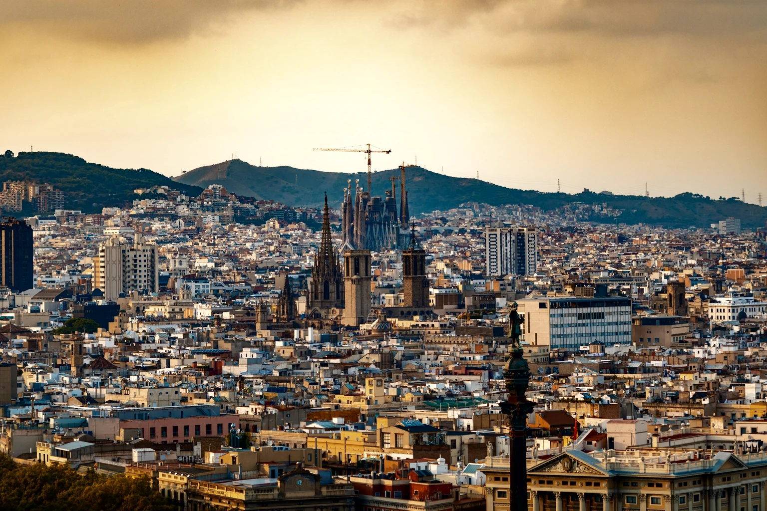 Barcelona's Gothic Quarter at sunset, the cathedral and the Sagrada Família under the Collserola hills