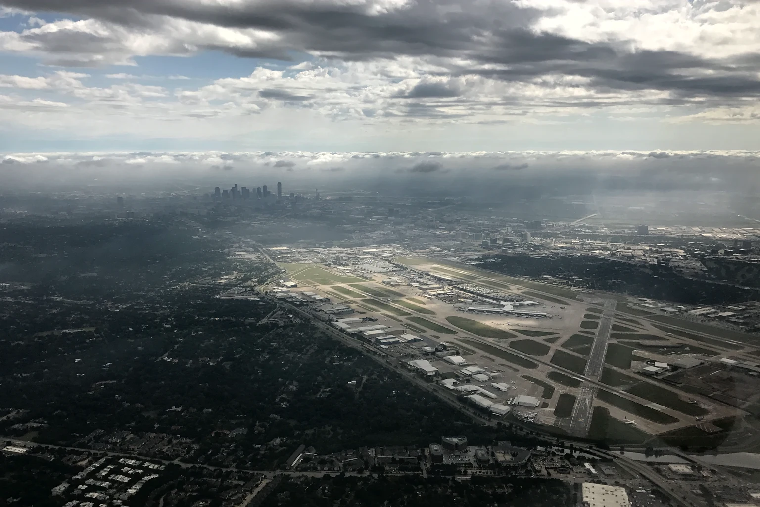 Love Field from the air under breaking cloud, downtown Dallas on the horizon