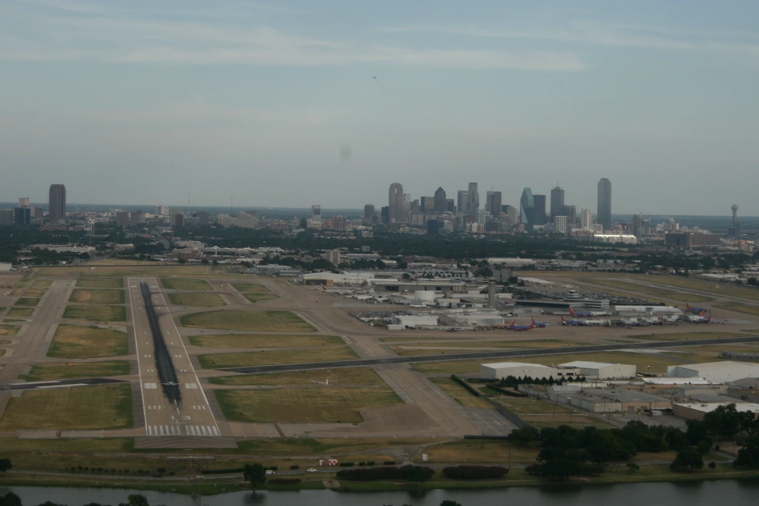 Love Field's runways from the north-west, over Bachman Lake, with the downtown Dallas skyline behind