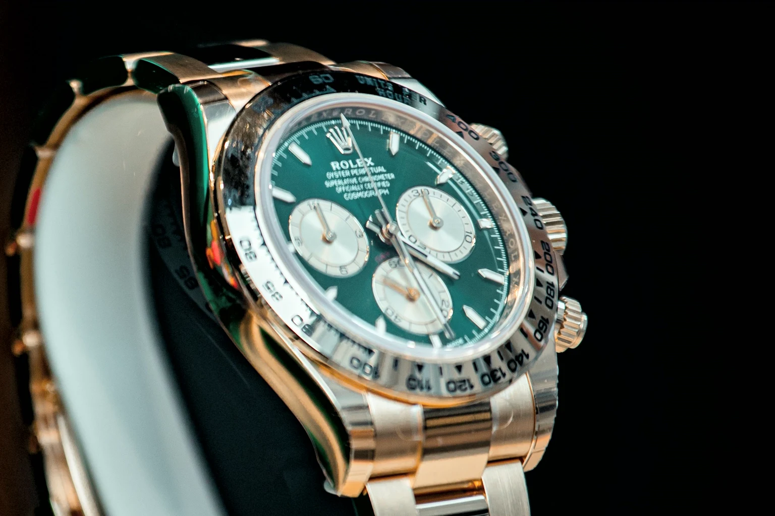 Close view of the green Daytona dial with golden counters and the engraved tachymetric bezel