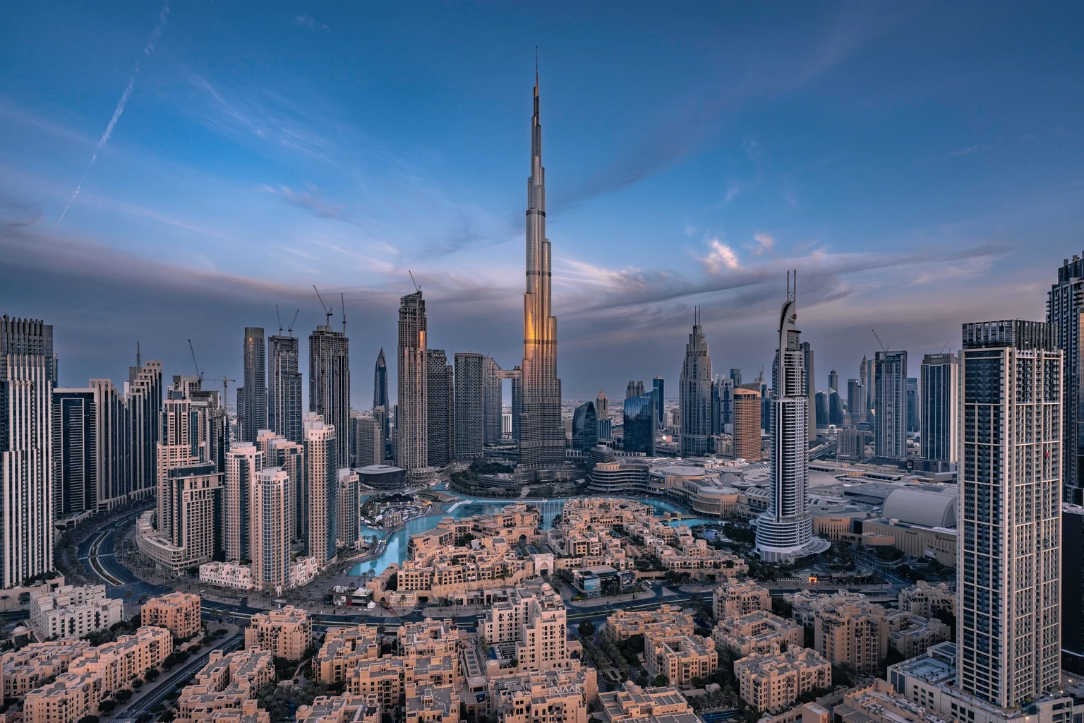 The Dubai skyline at dusk with the Burj Khalifa rising above the towers of Downtown
