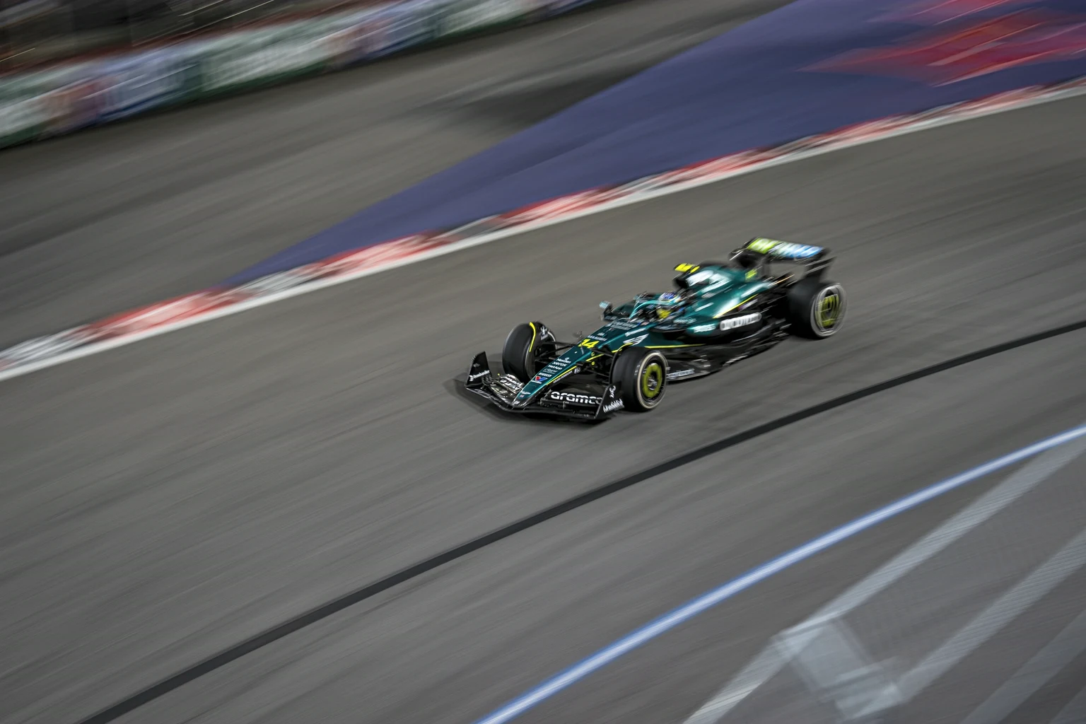 A Formula 1 car blurred by speed on the Las Vegas Strip Circuit at night