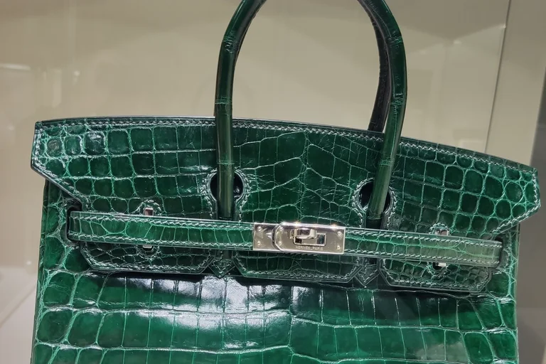 A green crocodile Hermès Birkin with palladium hardware on display at an auction preview