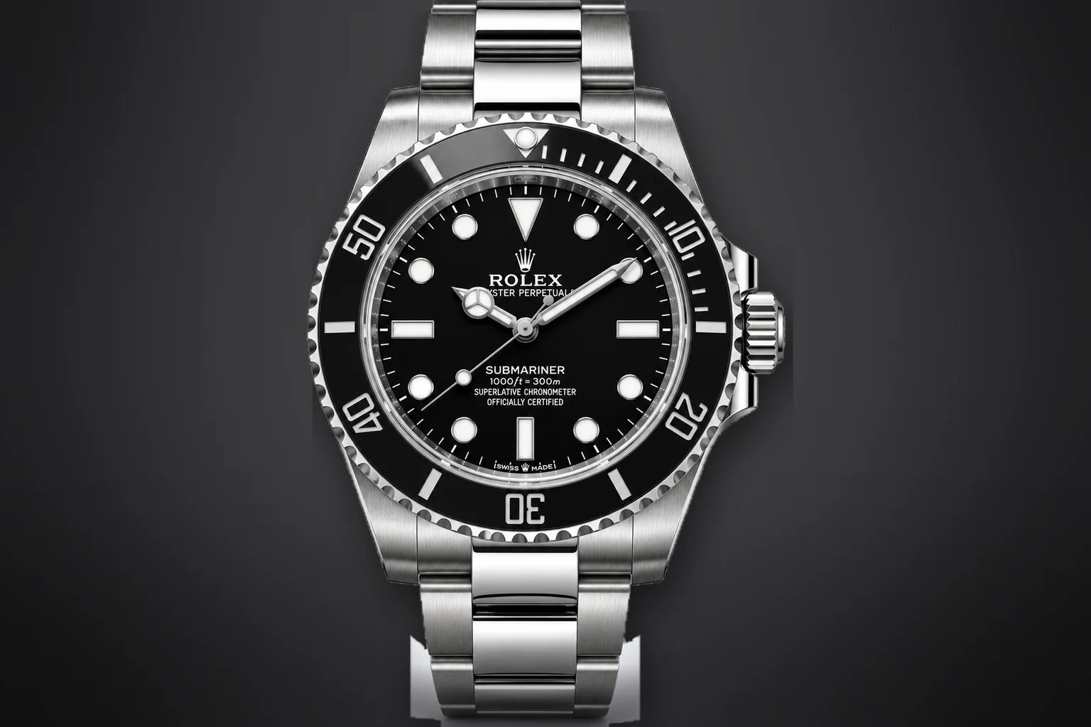 A steel Rolex Submariner with a black dial and black ceramic bezel on a steel Oyster bracelet, lit against a dark ground