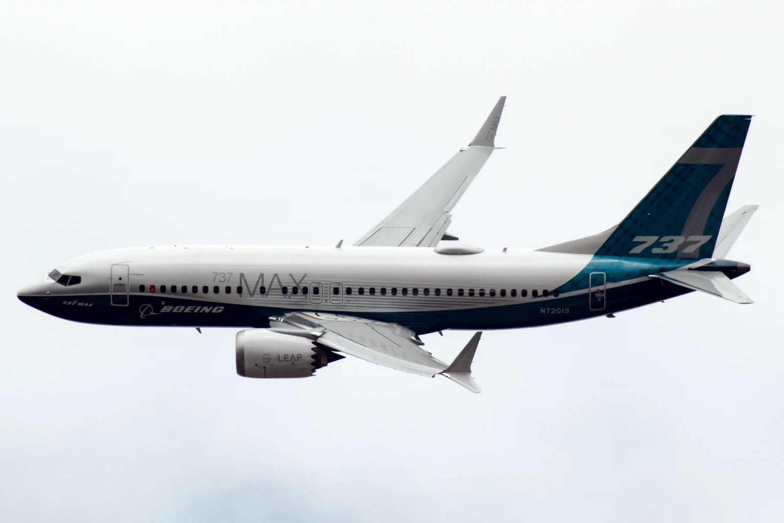 Stand-in photograph, not a BBJ: Boeing's own 737 MAX 7 test aircraft, the airliner the BBJ MAX 7 is built from, in Boeing's teal and navy house colours, flying past gear-up under a white sky at Farnborough.