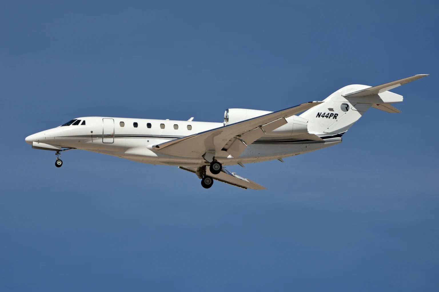 A white Cessna Citation X, the model the X+ developed from, on approach against a clear blue sky, side-on from slightly below.