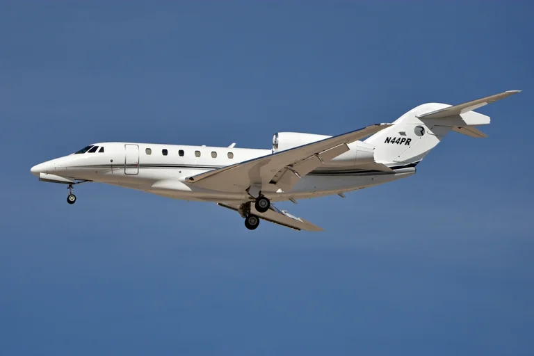 A white Cessna Citation X, the model the X+ developed from, on approach against a clear blue sky, side-on from slightly below.