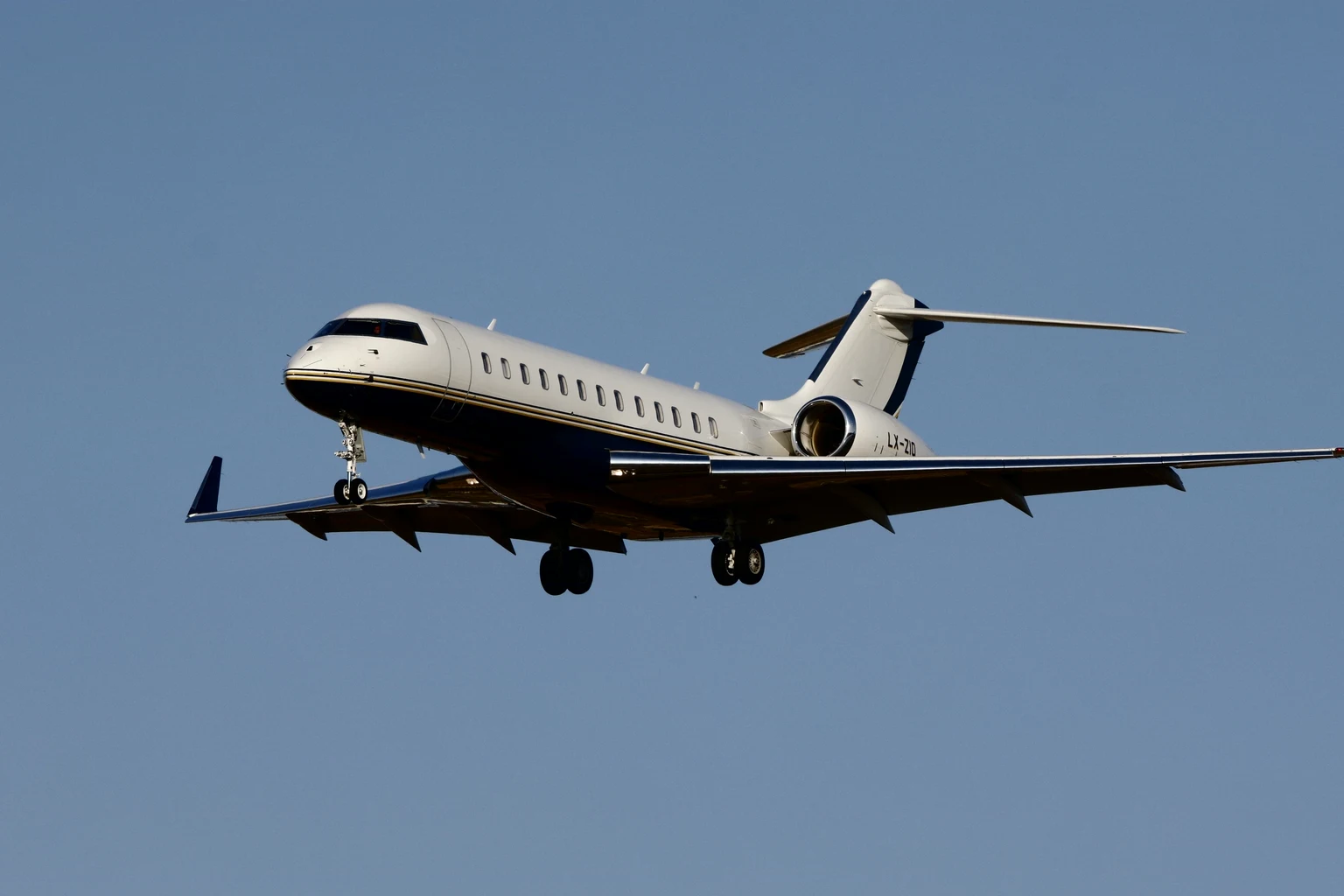 A Bombardier Global business jet on approach against a clear sky