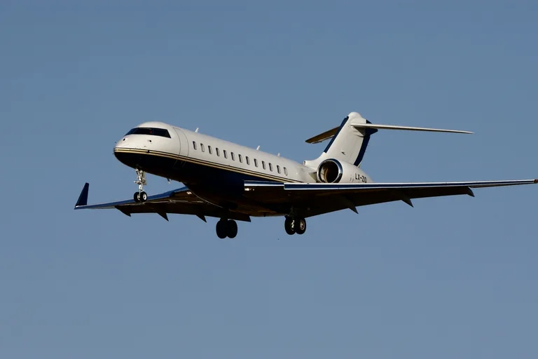 A Bombardier Global in flight against a clear sky