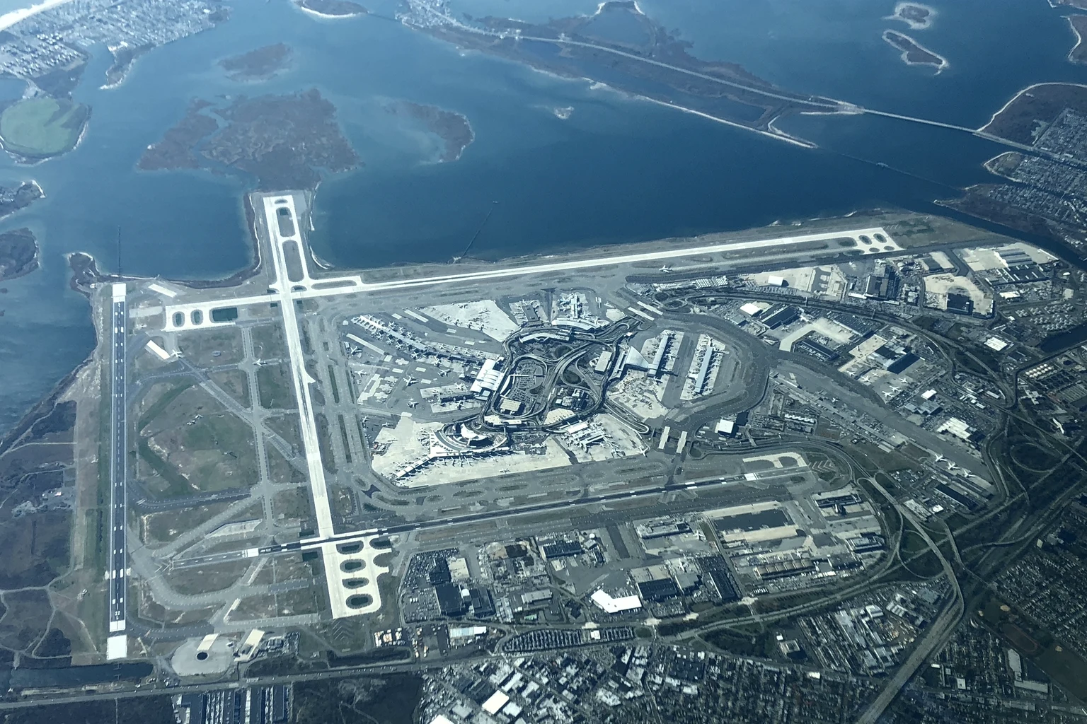 JFK Airport from the air, its crossing runways on the edge of Jamaica Bay
