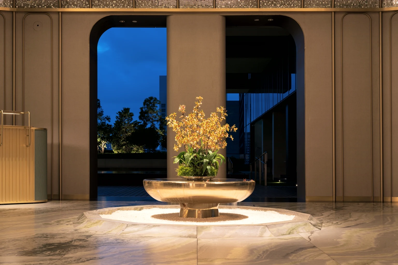 A hotel lobby at the blue hour, lamps lit and the street beyond the glass