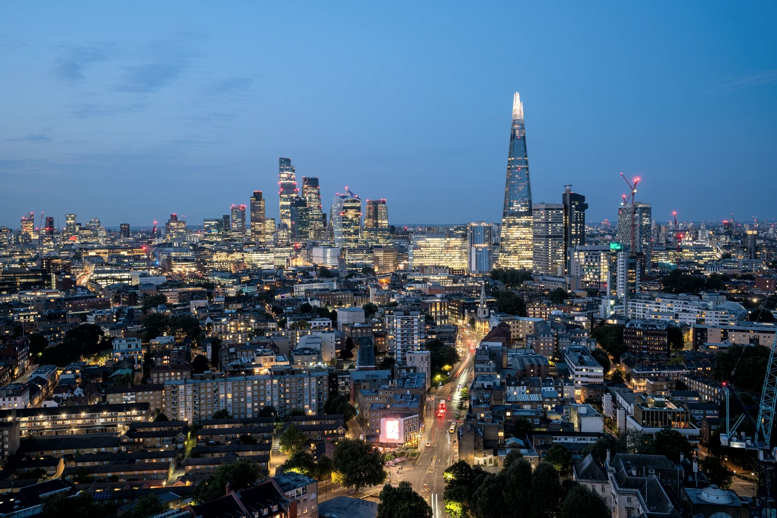 London from the air at blue hour, the Shard and the City lit