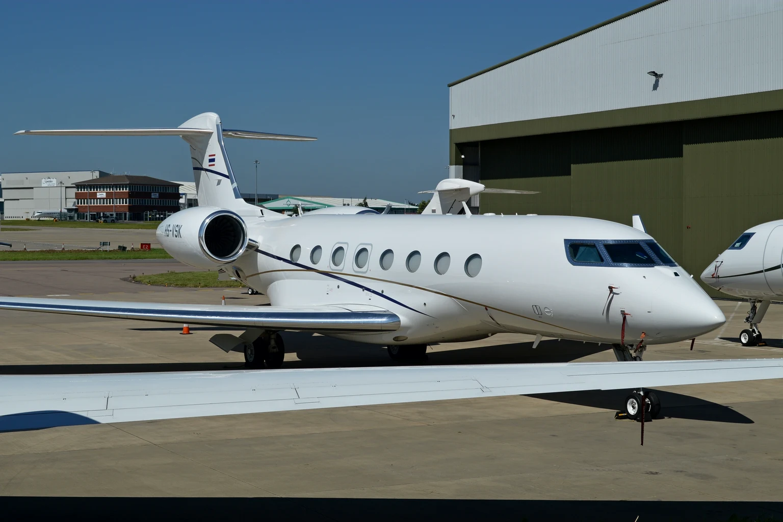A Gulfstream G650 parked on the private ramp at London Luton in bright sun