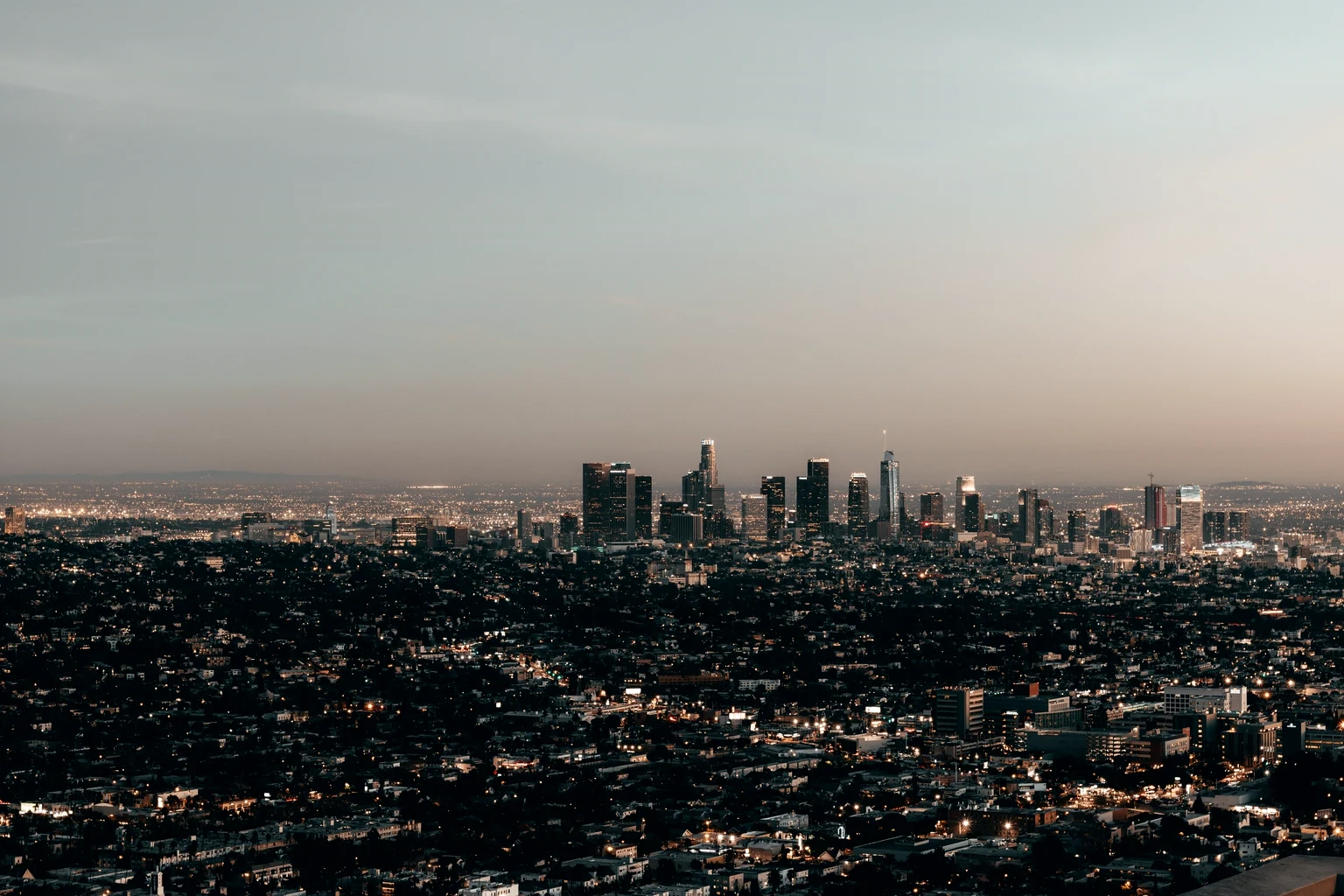 The Los Angeles skyline at dusk, seen from the hills with the basin lit below