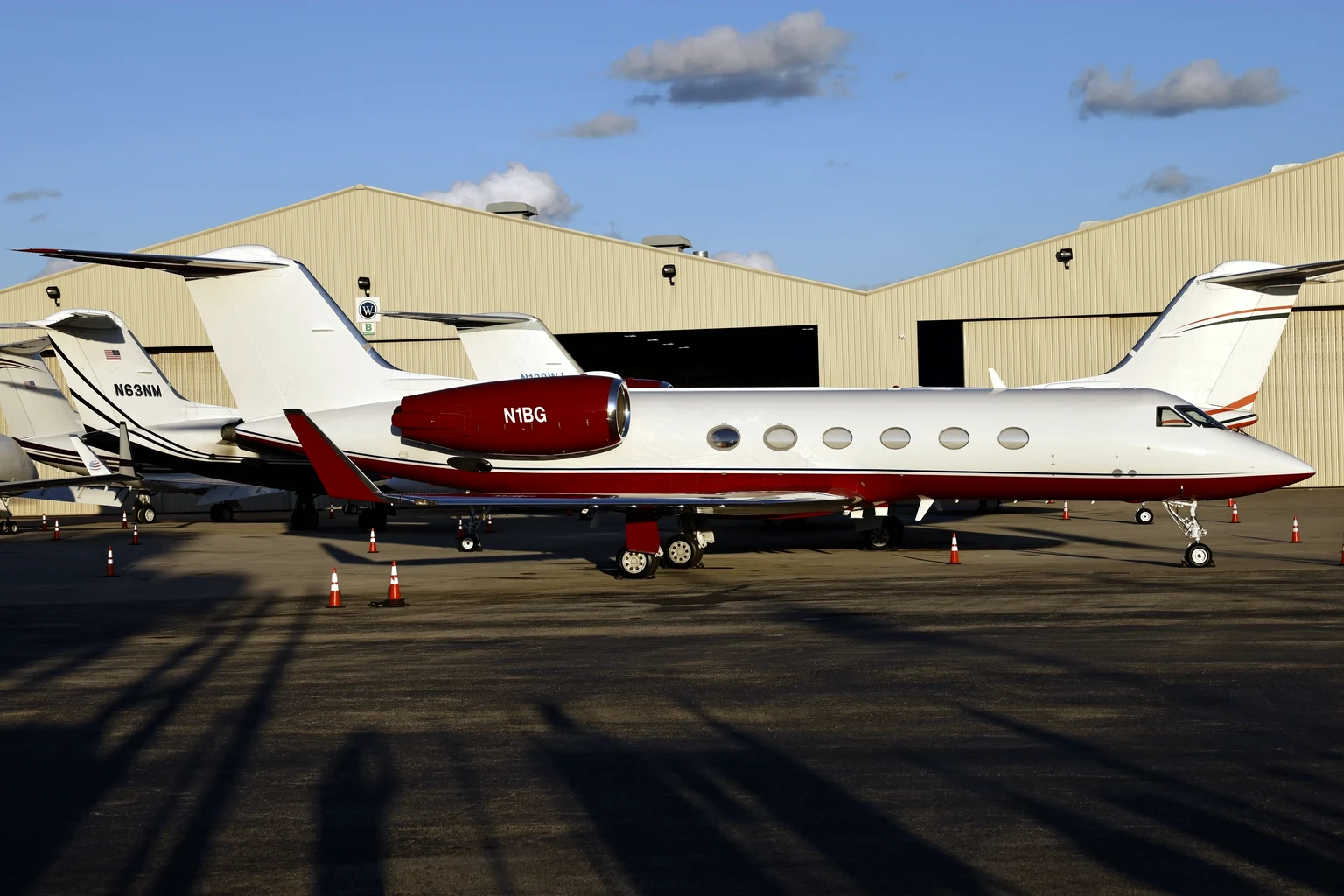 Gulfstreams lined up outside a hangar at Fort Lauderdale Executive in evening light