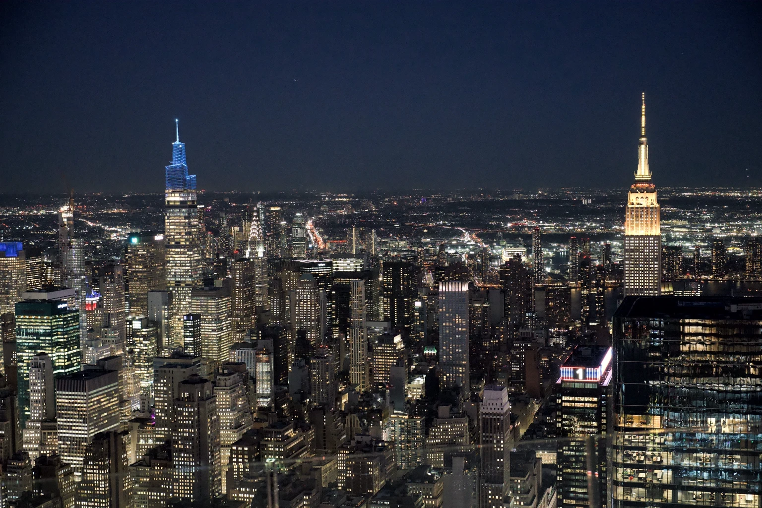 Manhattan at night from the air, the Empire State and Chrysler buildings lit