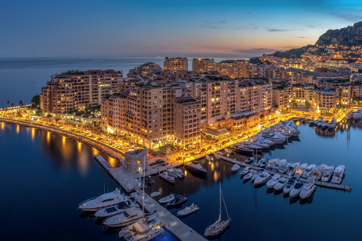 Monaco's Fontvieille harbour and its yachts at dusk, seen from above