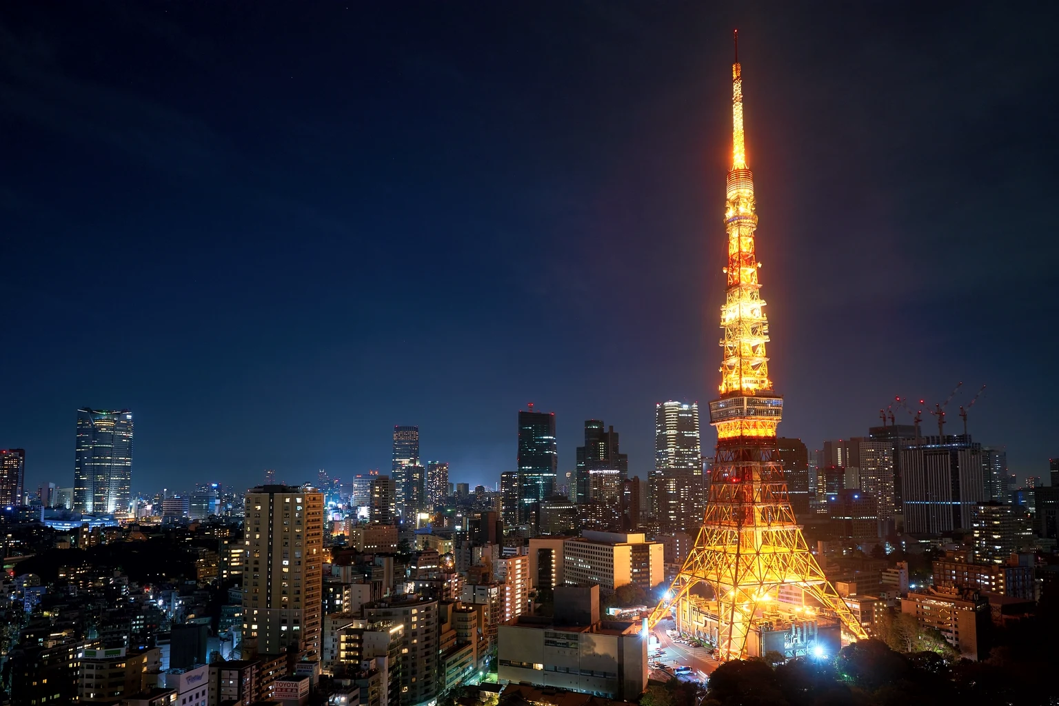 Tokyo Tower lit orange at night with the city around it