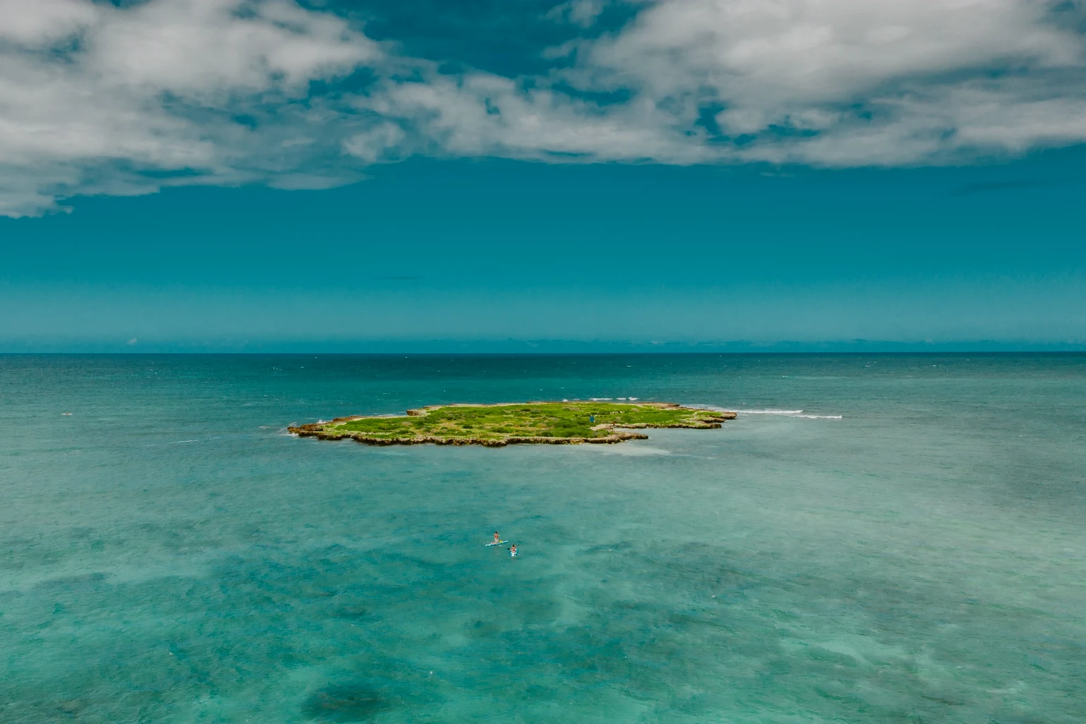 A small island in turquoise Caribbean water off Turks and Caicos, seen from the air