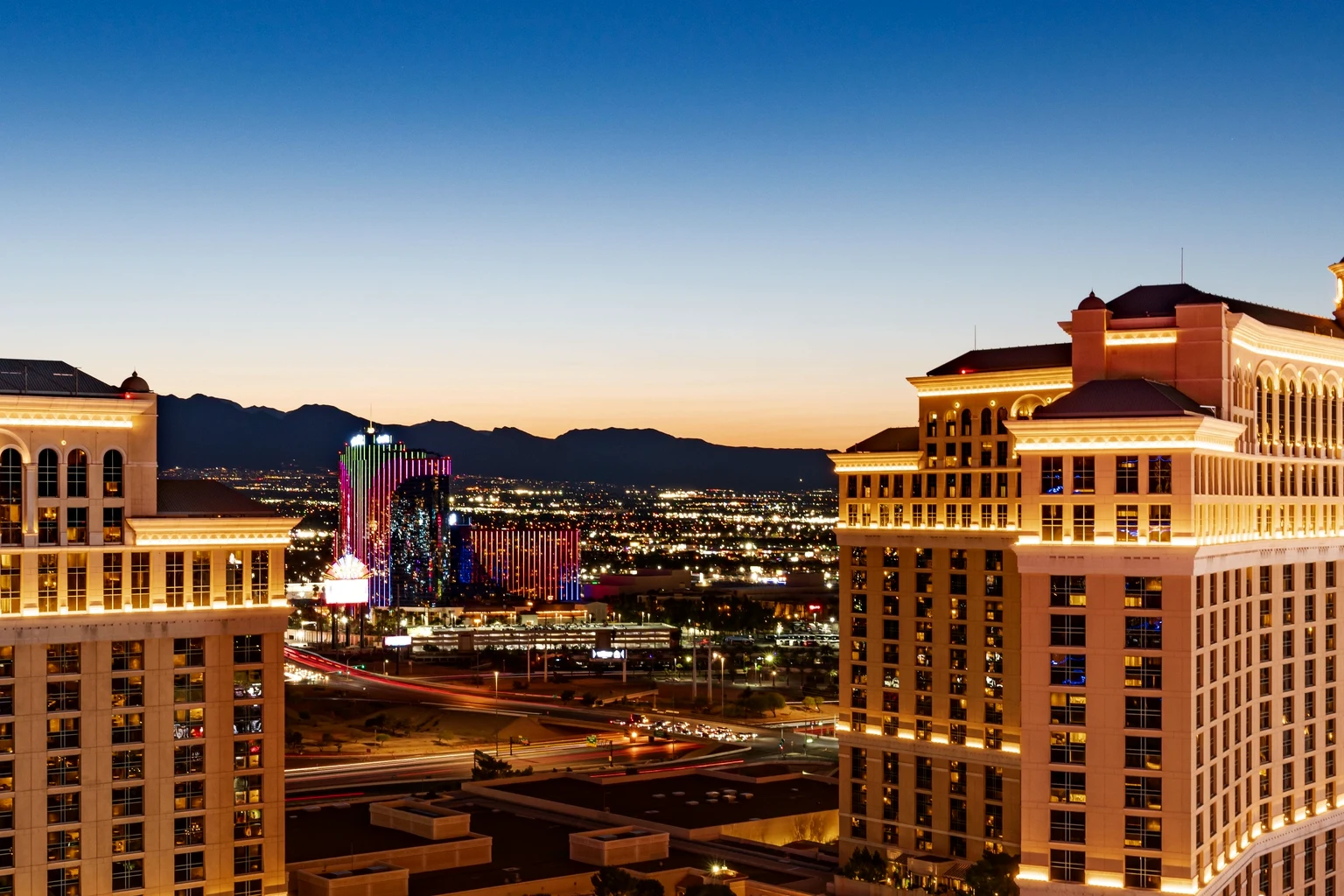 The Bellagio and its lake from above at dusk, the Strip lit behind