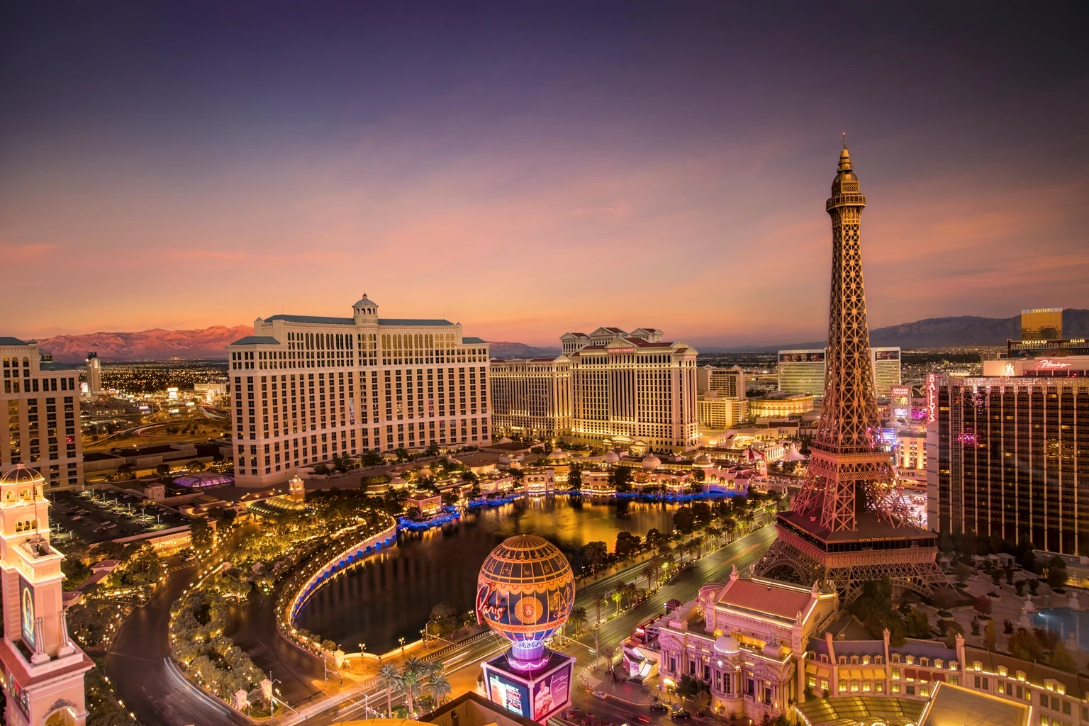 The Las Vegas Strip from the air at sunset, with the Bellagio fountains and the Paris tower lit