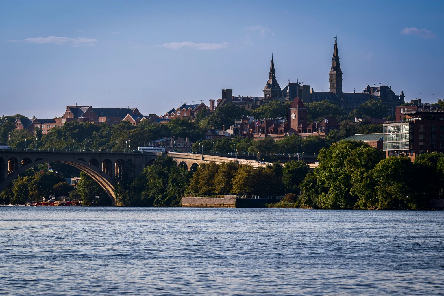 The Georgetown waterfront and Key Bridge at dusk, the university spires behind