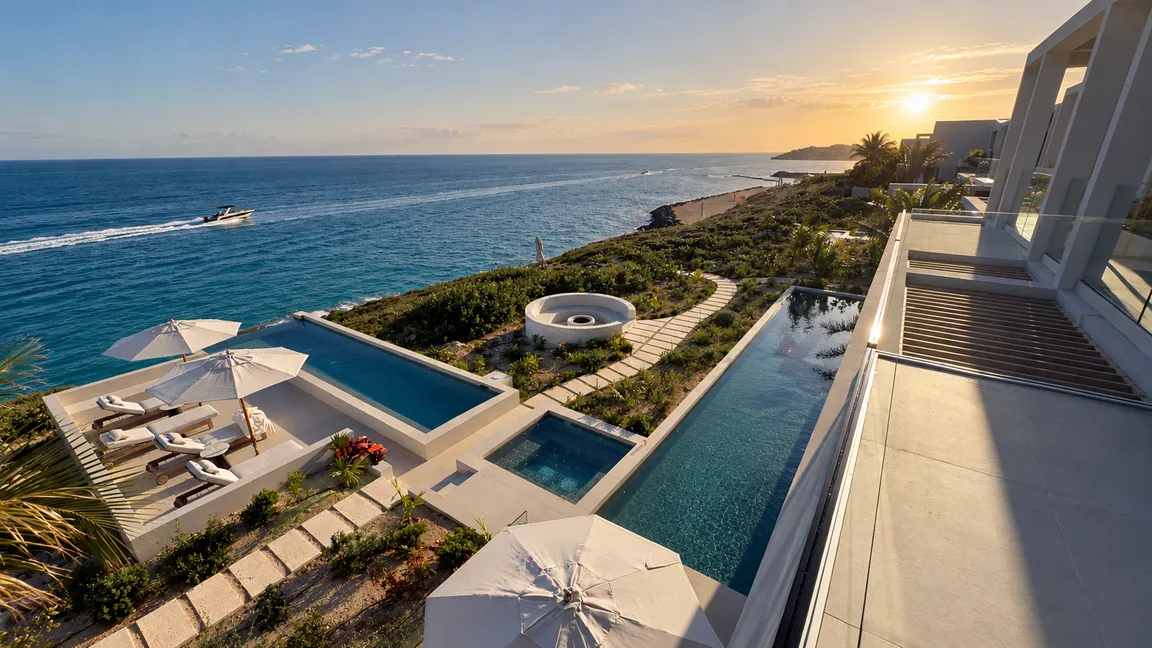 A clifftop villa with infinity pools above the sea at sunset