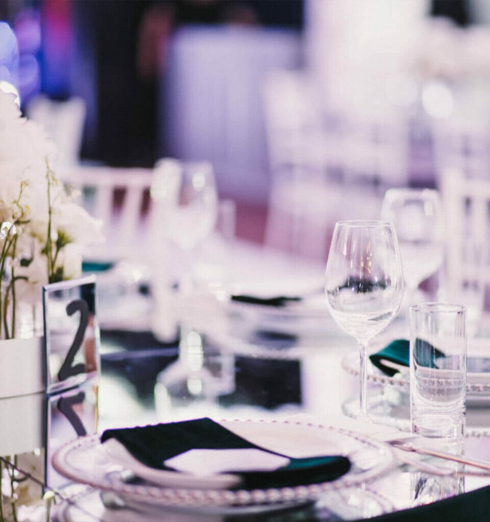 A black and white table setting curated by a chef, featuring white plates and silverware.